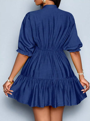 Navy blue tiered mini dress with elastic waist, puff sleeves, and ruffled hem.