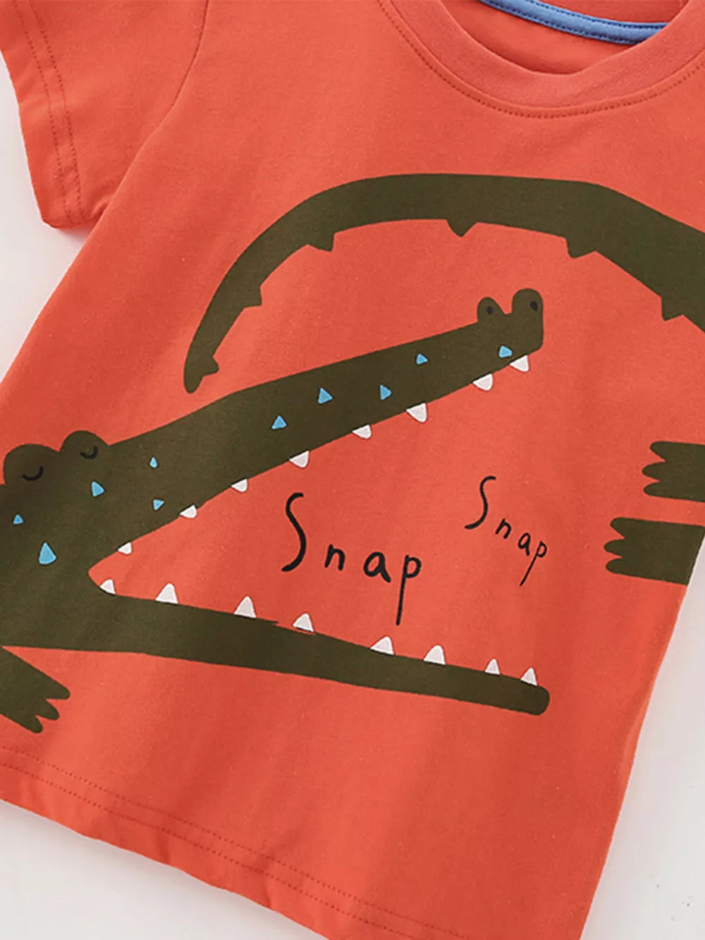 Coral cotton toddler t-shirt with a playful green crocodile graphic and "Snap" text.