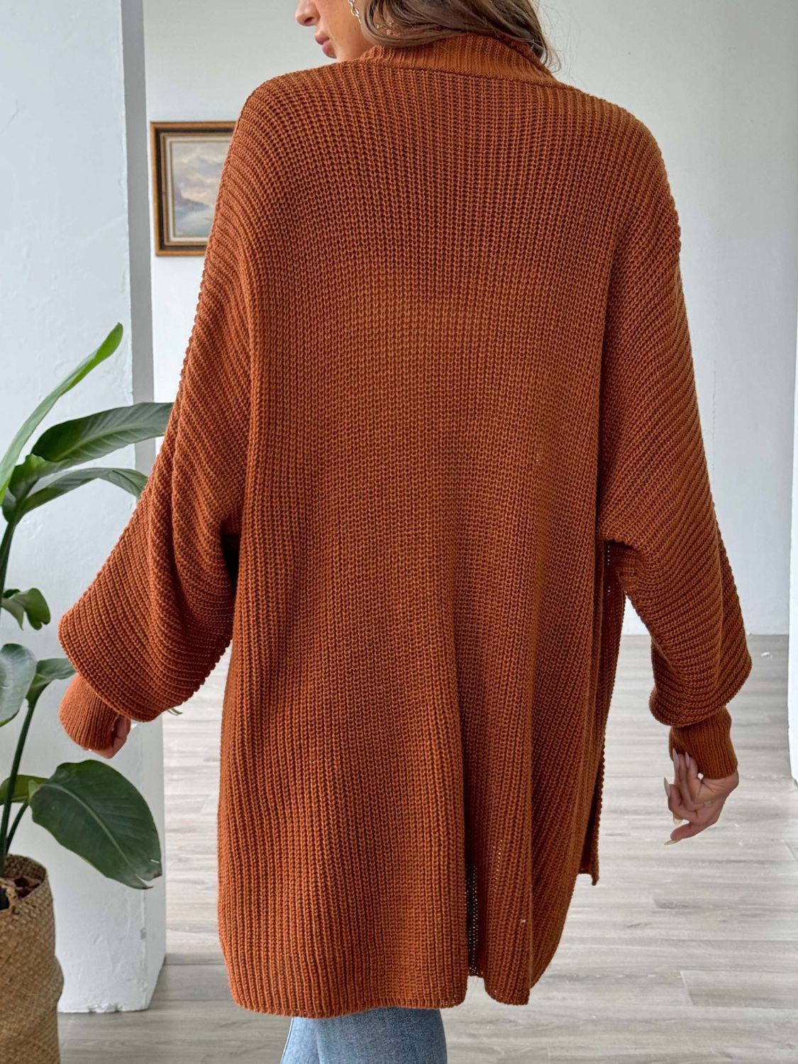 Ochre ribbed knit cardigan with pearl buttons and relaxed fit.