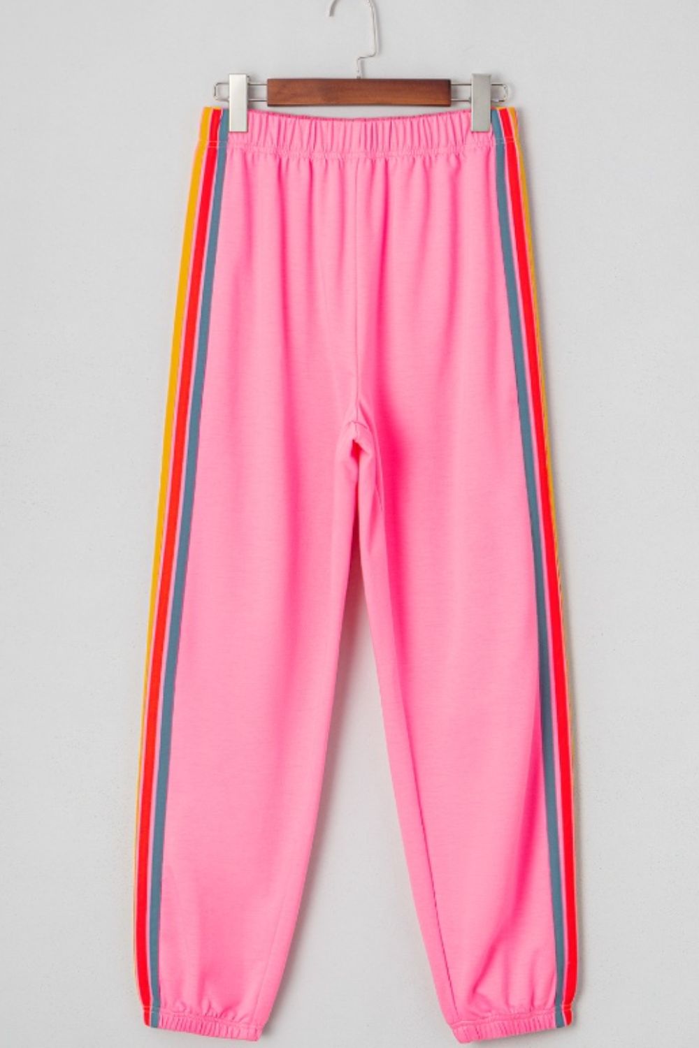 Pink track pants with rainbow side stripes