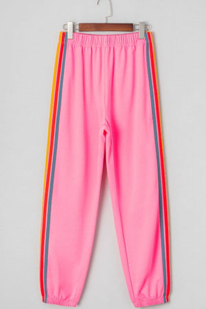 Pink track pants with rainbow side stripes