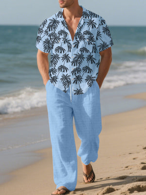 Men's pastel blue relaxed fit pants with drawstring waist, paired with a palm print short sleeve button-down shirt.