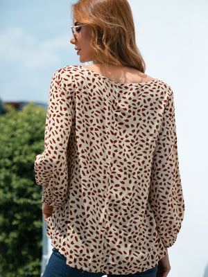 Beige dotted print balloon sleeve blouse with a scoop neckline.
