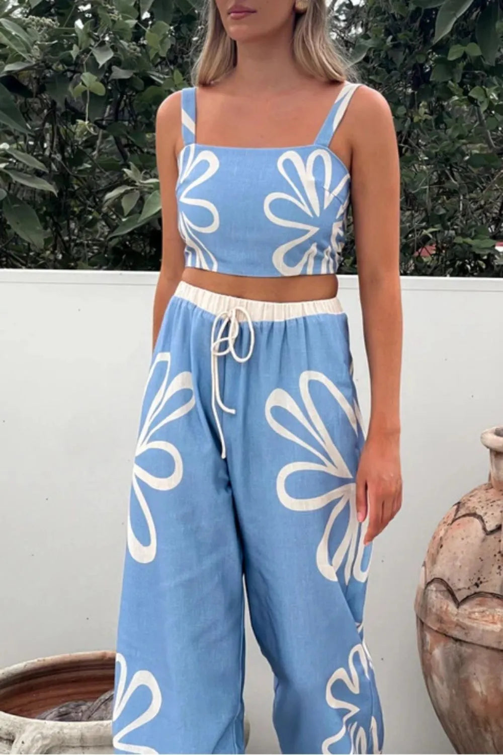 Light blue linen co-ord set with white floral print, square neck crop top and wide leg pants with drawstring.