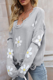 Gray distressed knit sweater with white daisy appliques and frayed neckline and hem.