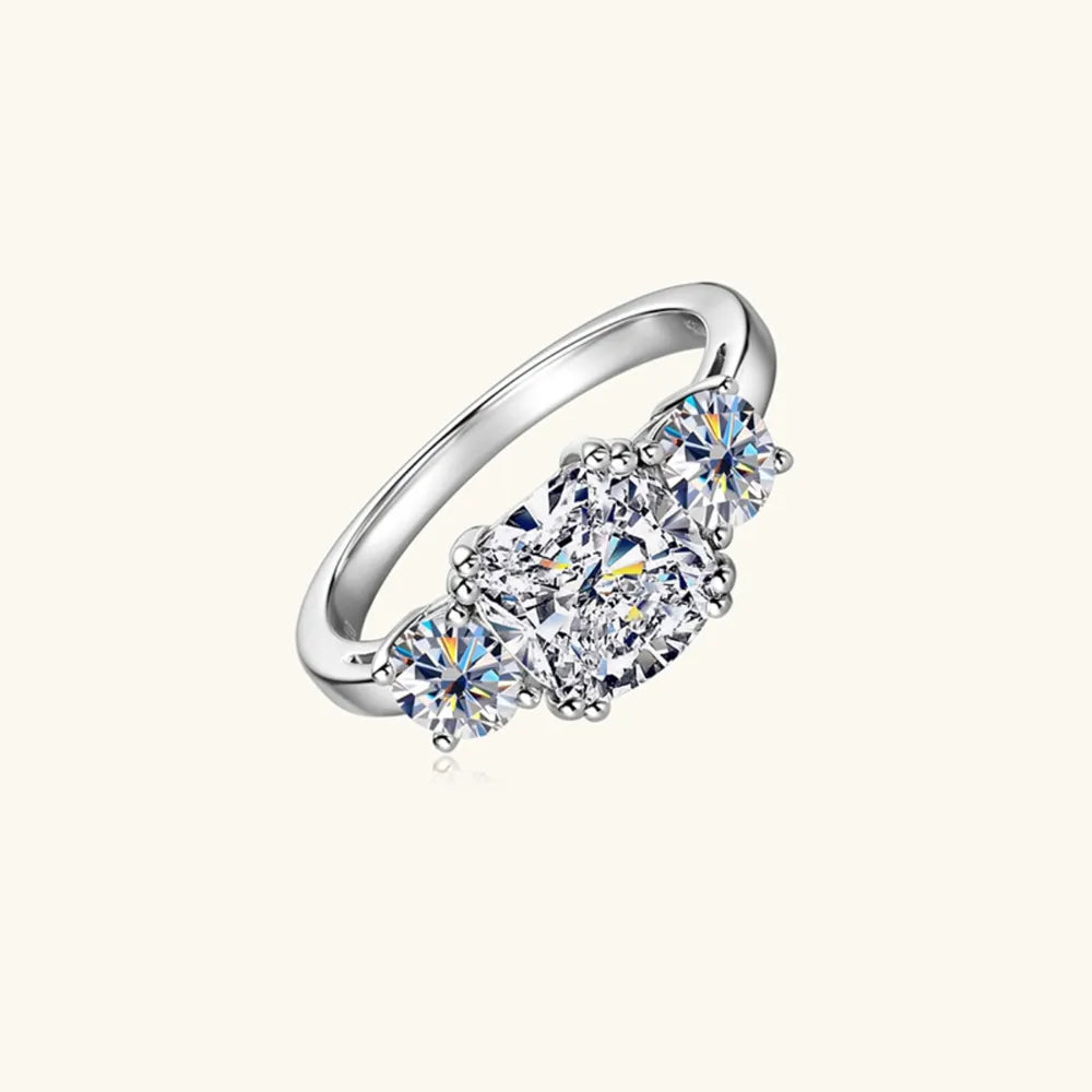 Silver three-stone cushion cut moissanite ring with sparkling stones.