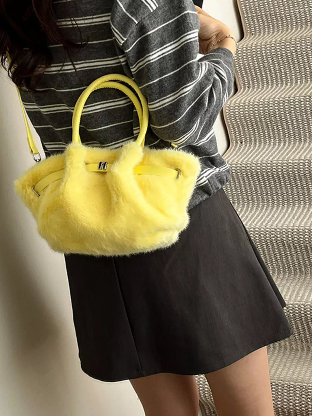 Yellow plush crossbody bag with chic buckle detail and top handles.