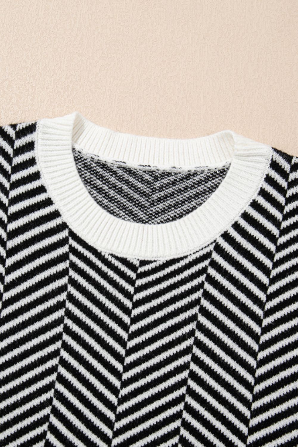 Black and white chevron knit crewneck sweater with white ribbed neckline.