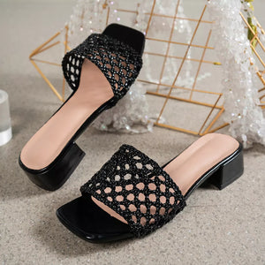 Black woven mid-heel sandals with square toe and block heel.