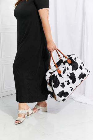 Cowhide print duffel bag with brown leather trim and handles