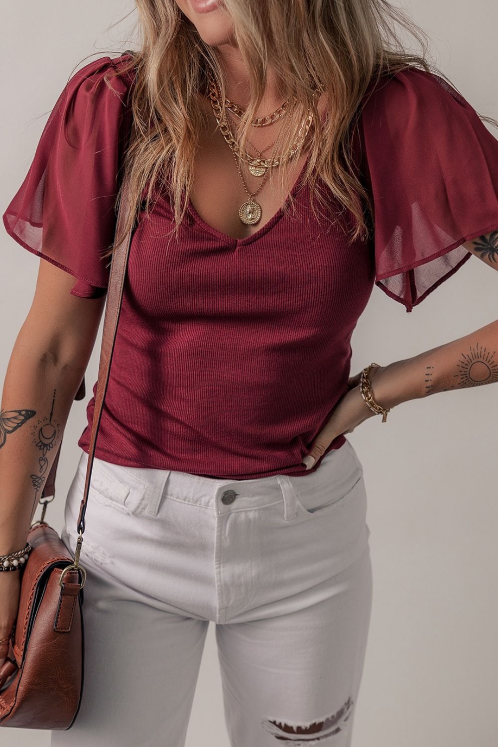 Burgundy ribbed knit top with flutter sleeves and v-neck.