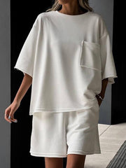 White raw-edge pocket tee and bermuda shorts set with frayed hems and cuffs.