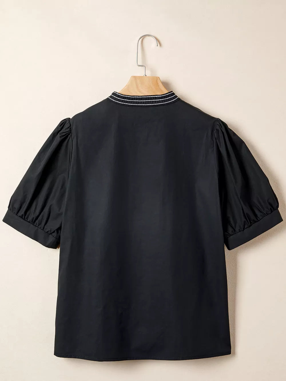 Black maternity overshirt with embroidered neckline and puff sleeves.