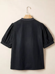 Black maternity overshirt with embroidered neckline and puff sleeves.