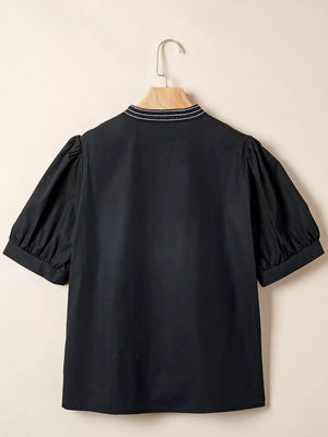 Black maternity overshirt with embroidered neckline and puff sleeves.