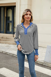 Striped long sleeve blouse with blue neckline and cuffs, henley detail