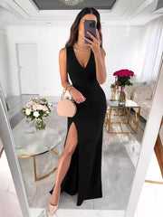 Black ruched maxi dress with V-neck and high slit, sleeveless.