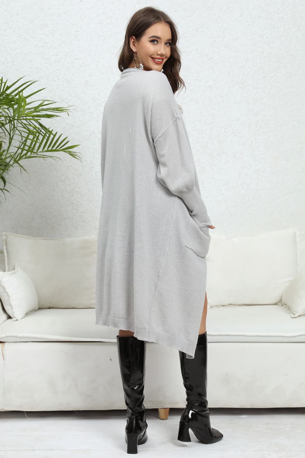 Light gray oversized pocketed knit cardigan with long sleeves and a relaxed fit.