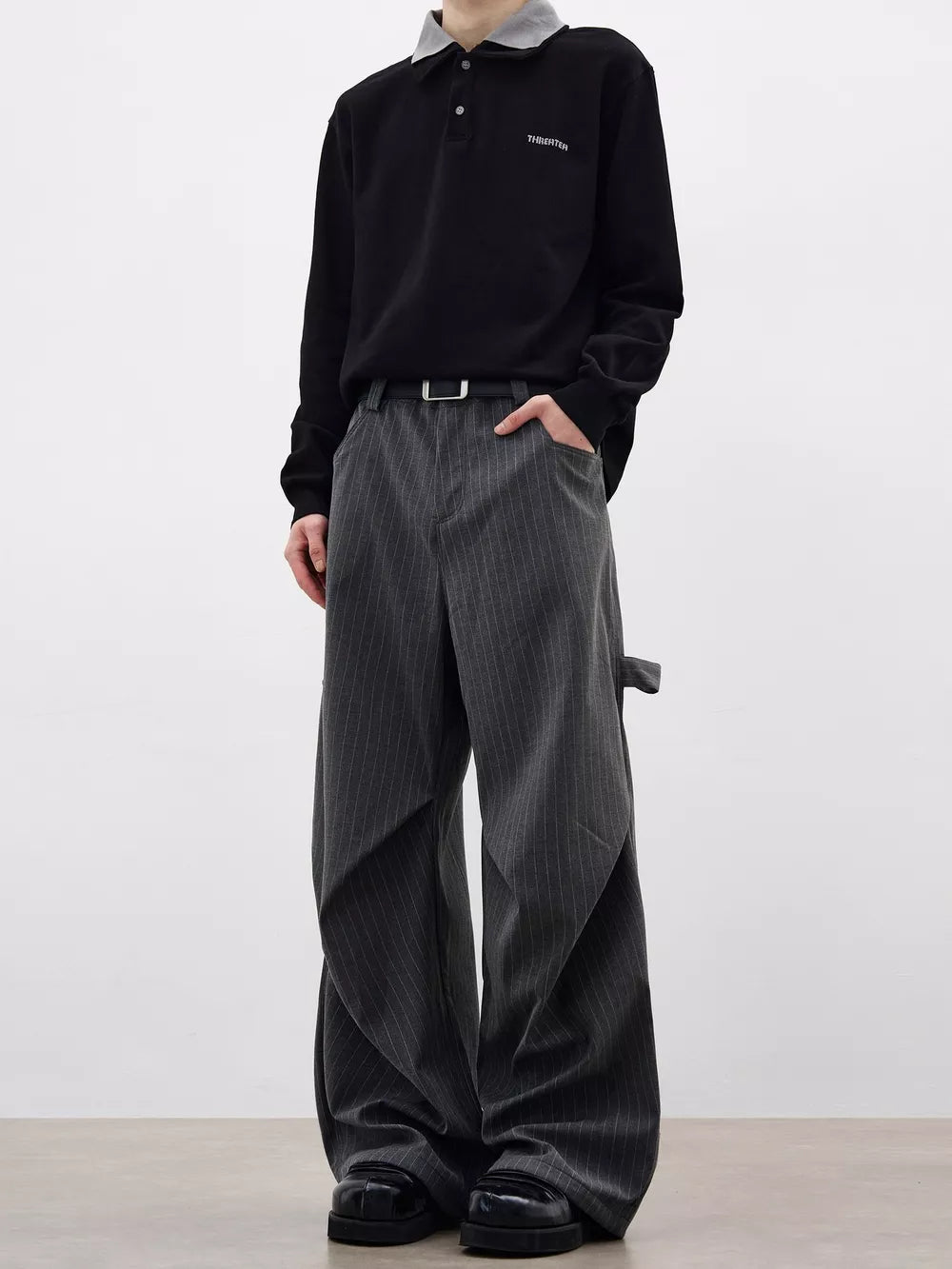 Men's grey pinstripe wide-leg sweatpants with pockets and a relaxed fit.