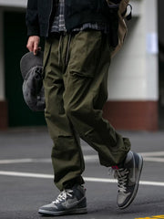 Men's army green drawstring sweatpants with multiple pockets and a relaxed fit.