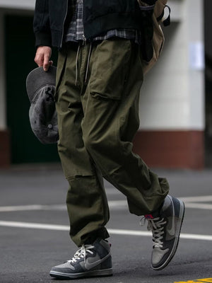 Men's army green drawstring sweatpants with multiple pockets and a relaxed fit.
