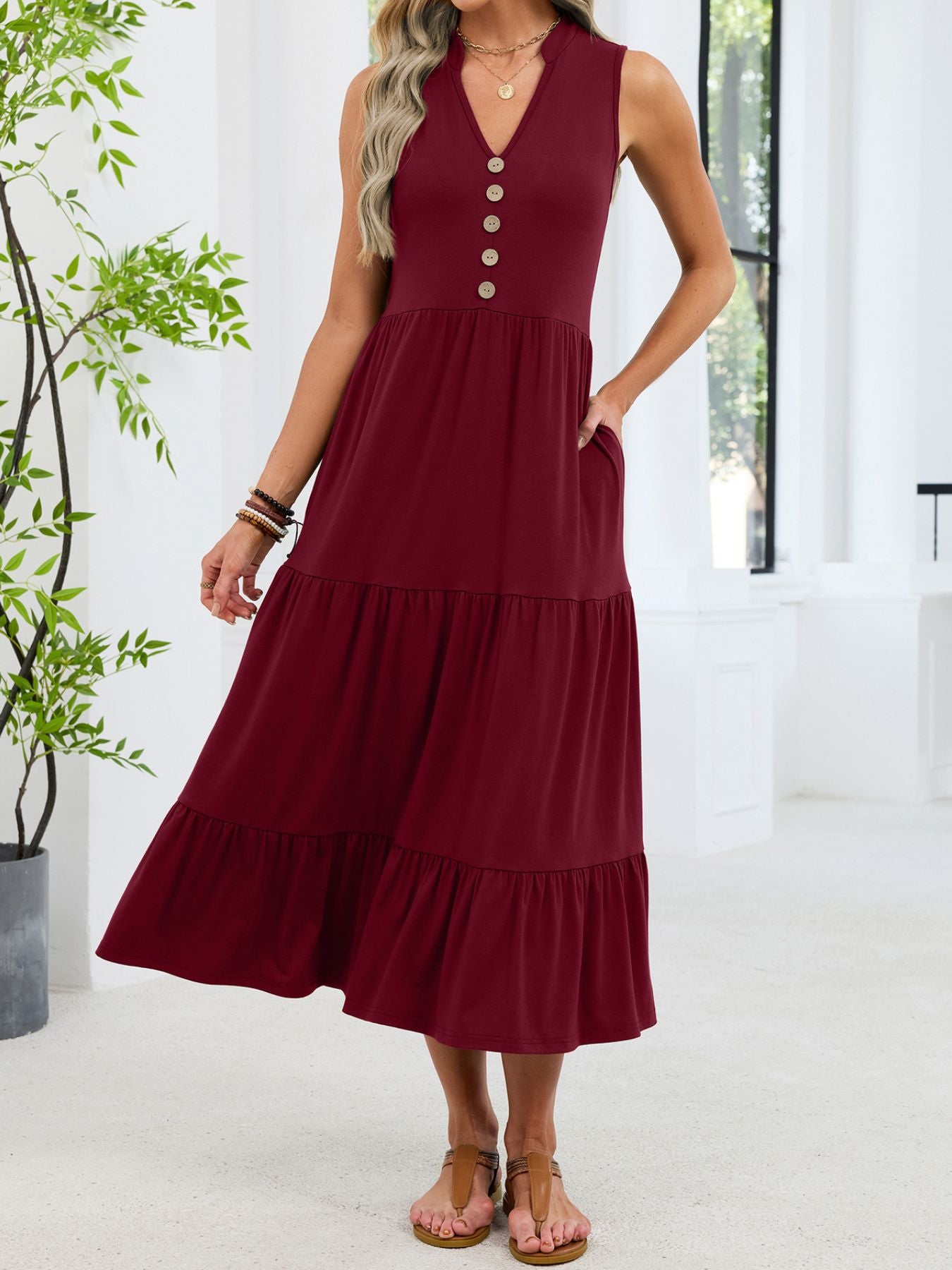 Burgundy tiered midi dress with notched V-neck and decorative buttons.