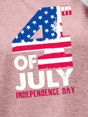 Graphic tee with 4th of July text and American flag design in red, white, and blue on a dusty pink shirt.
