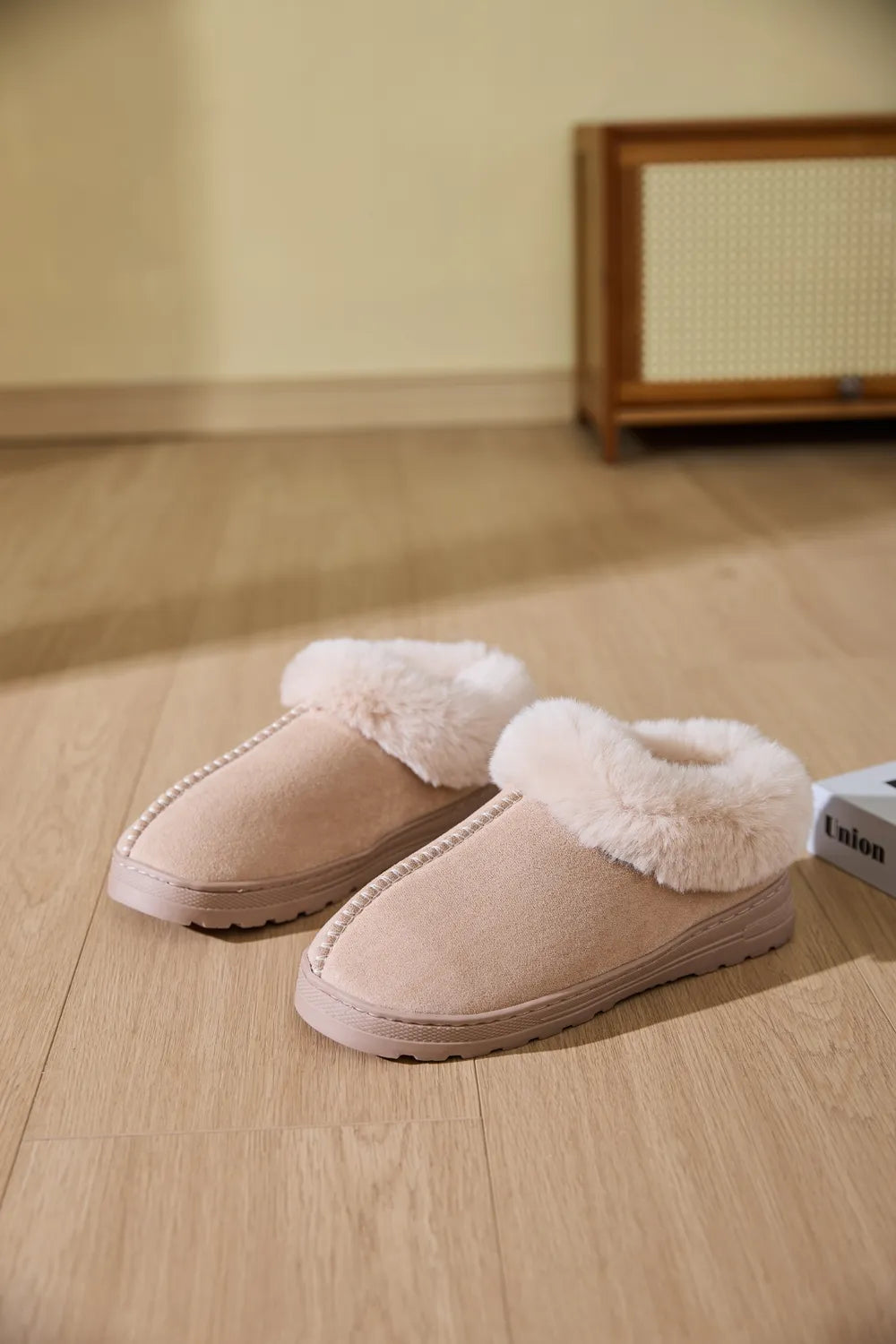 Suede house slippers with plush shearling trim in beige.