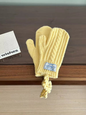 Yellow cable knit acrylic mittens with a braided detail and attached cord.