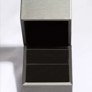 Open jewelry box with silver exterior and black interior.