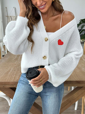 White balloon sleeve cardigan with red heart appliqué and button front.