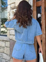 Light blue denim cropped jacket and asymmetric skort set with short sleeves.