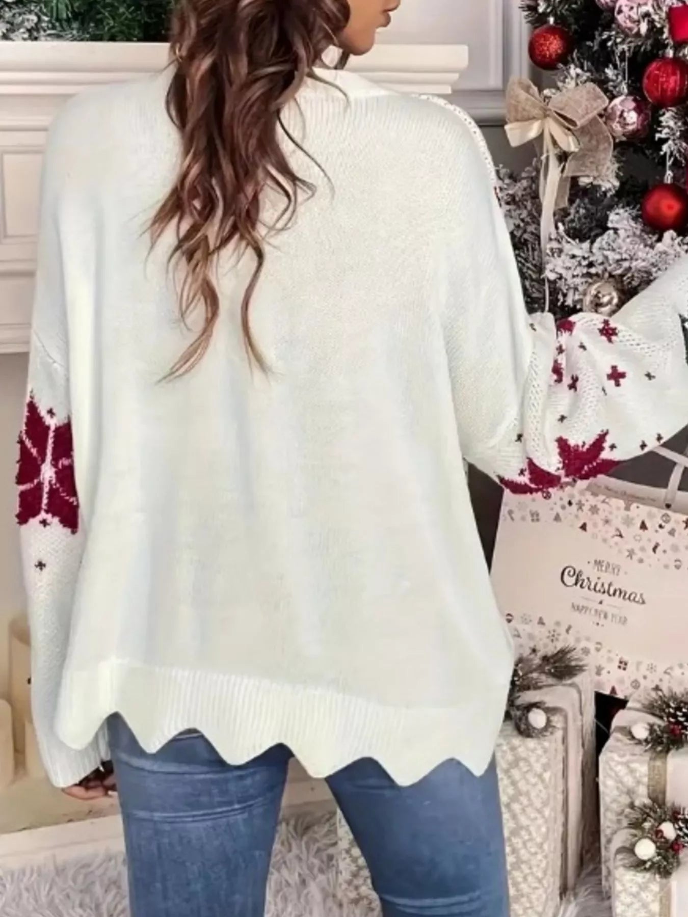 White acrylic blend sweater with red snowflake pattern on sleeves and scalloped hem.