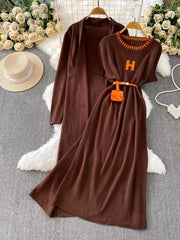 Brown knitted maxi dress and cardigan set with orange 'H' detail and belt.