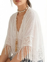White bohemian lace cover-up with fringe and V-neck, styled with necklaces.