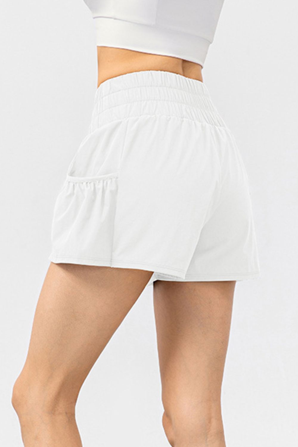 White active shorts with gathered waistline and side pocket detail.