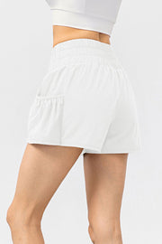 White active shorts with gathered waistline and side pocket detail.