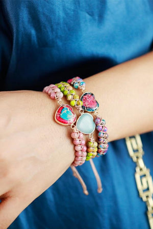 Multicolor beaded bracelets with heart-shaped stones and a light blue stone accent.
