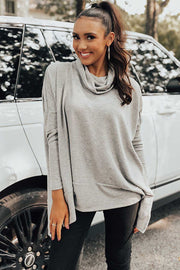 Light gray tunic with cowl neckline and long sleeves, styled with black leggings.