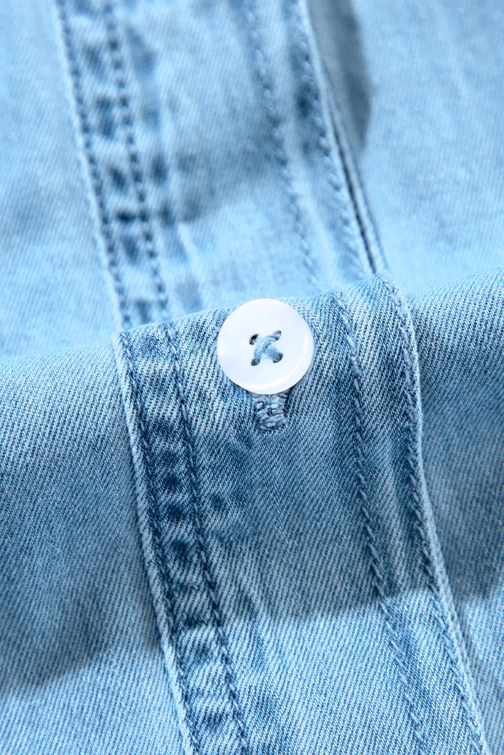 Light blue denim shirt dress with button detail and ruffled yoke.