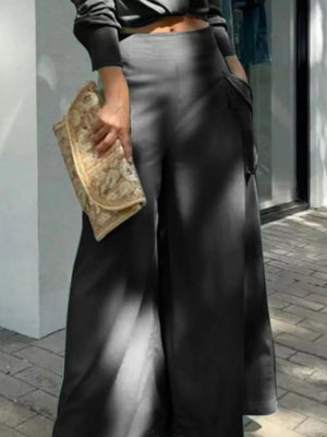 Black polyester two-piece set with wide-leg pants featuring pockets, styled with a clutch.