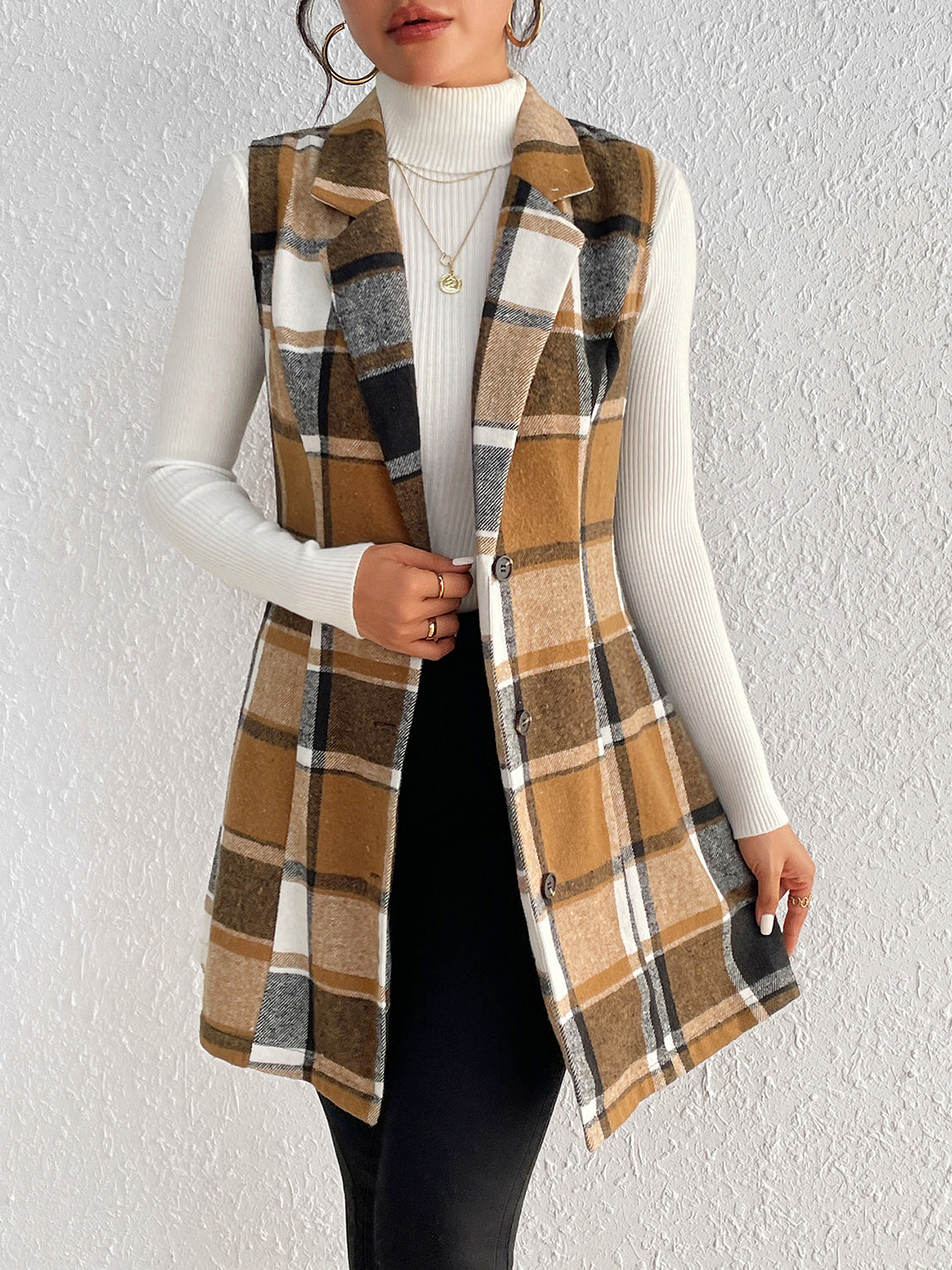 Camel plaid blazer vest with tailored silhouette and button front, worn over a white turtleneck.