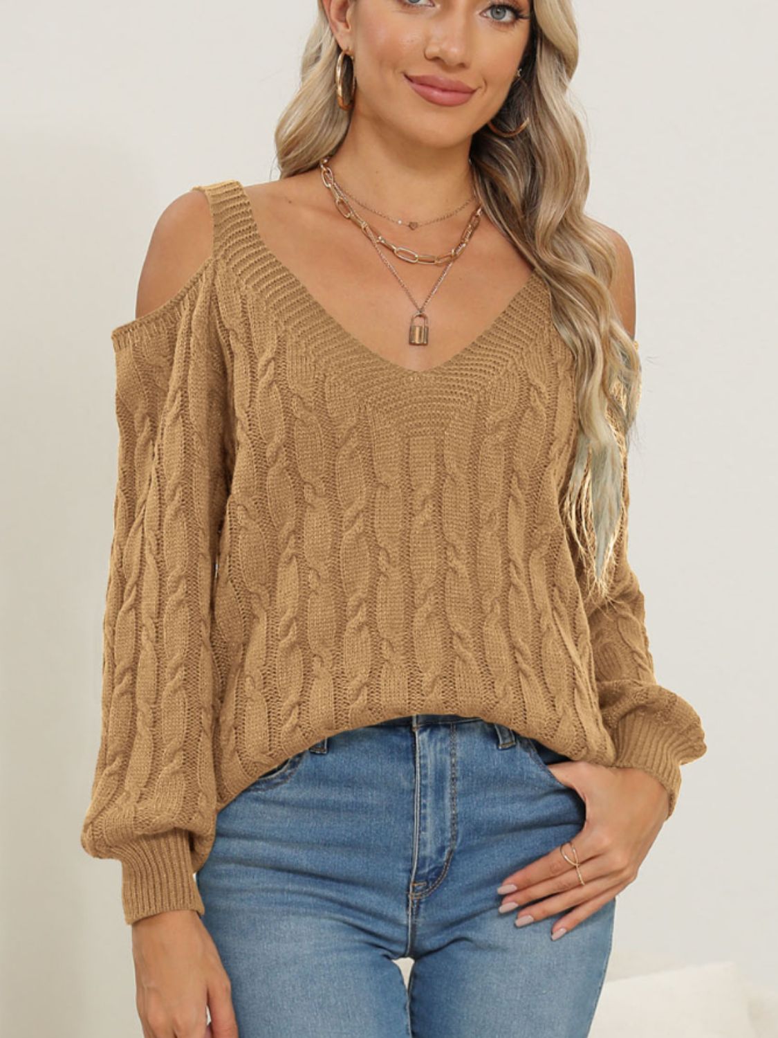 Camel cable knit cold shoulder sweater with V-neck and balloon sleeves.