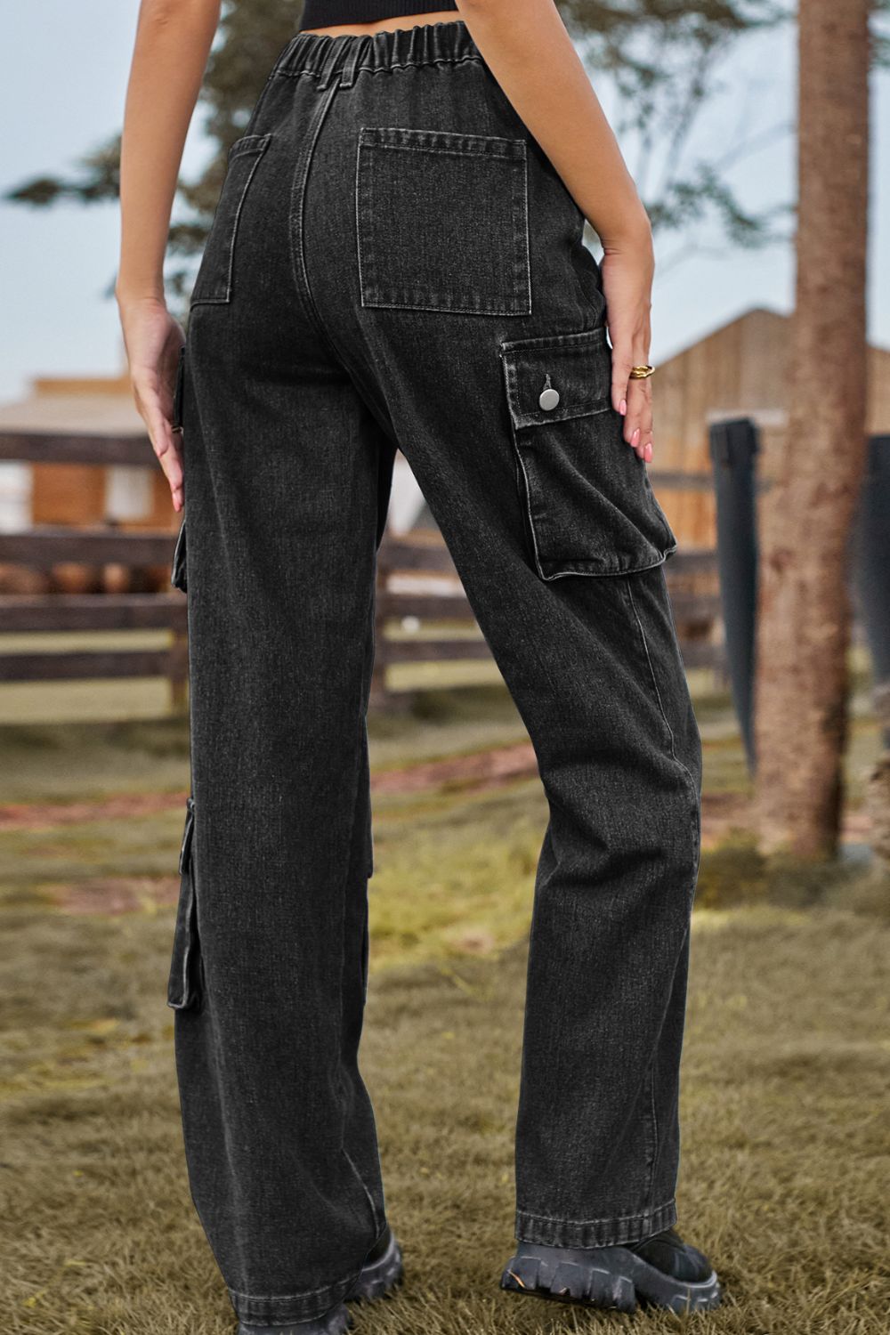Black denim cargo pants with relaxed wide leg and utility pockets.