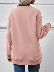 Blush pink crewneck sweatshirt with long sleeves and ribbed cuffs and hem.