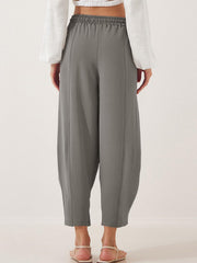 Gray balloon trousers with elastic waist and sculpted seam detail.