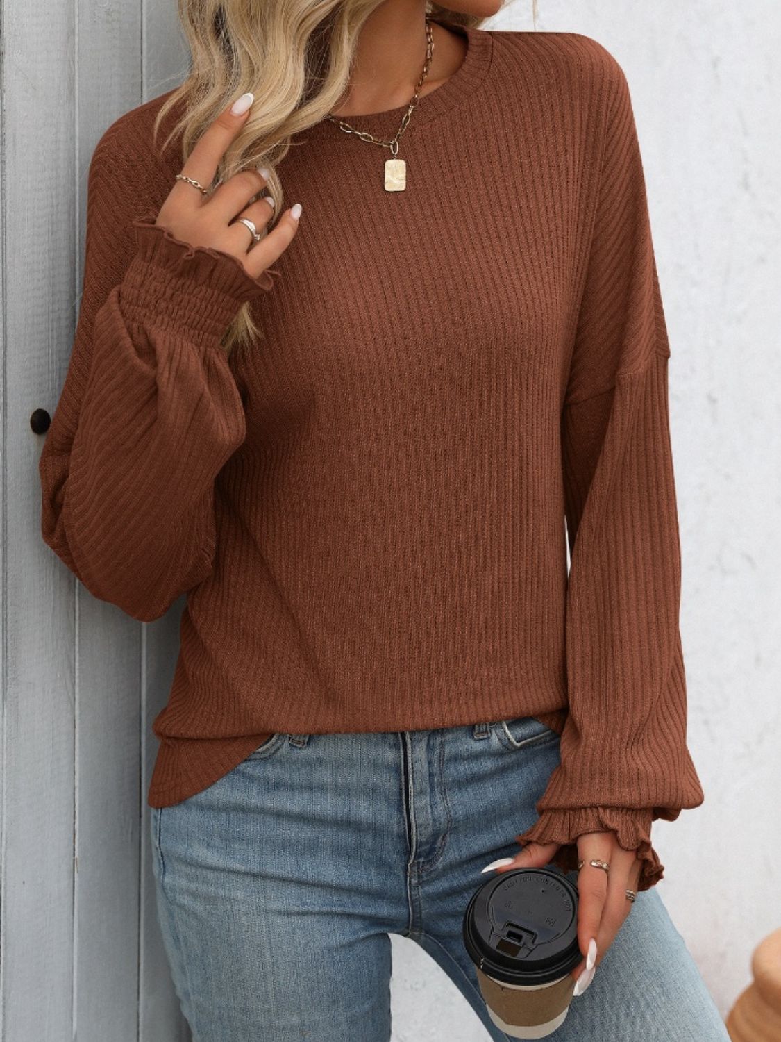 Textured ribbed knit blouse in dark brown with ruffled cuffs and crew neck.
