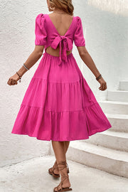 Hot pink tiered midi dress with puff sleeves and back tie detail