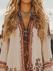 Embroidered long-sleeve mini dress in cream with a V-neck and colorful bohemian pattern.