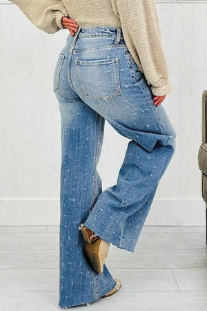 High-rise light wash denim jeans with distressed details and raw hem.